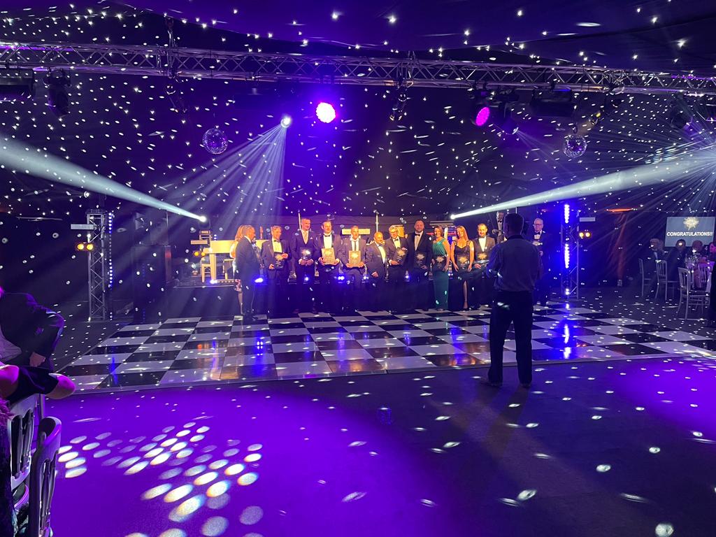 A group of people are standing on a dance floor at a party.