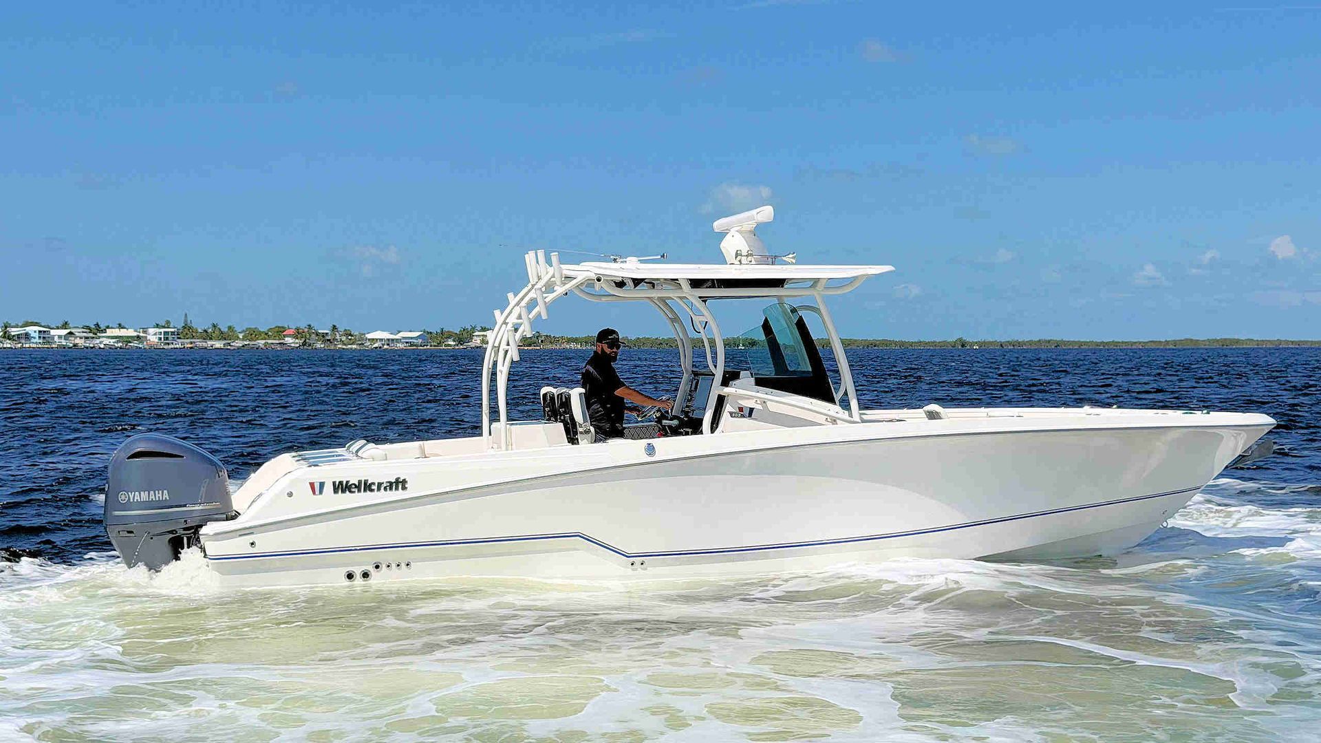 White center-console cruising on blue water under a clear sky