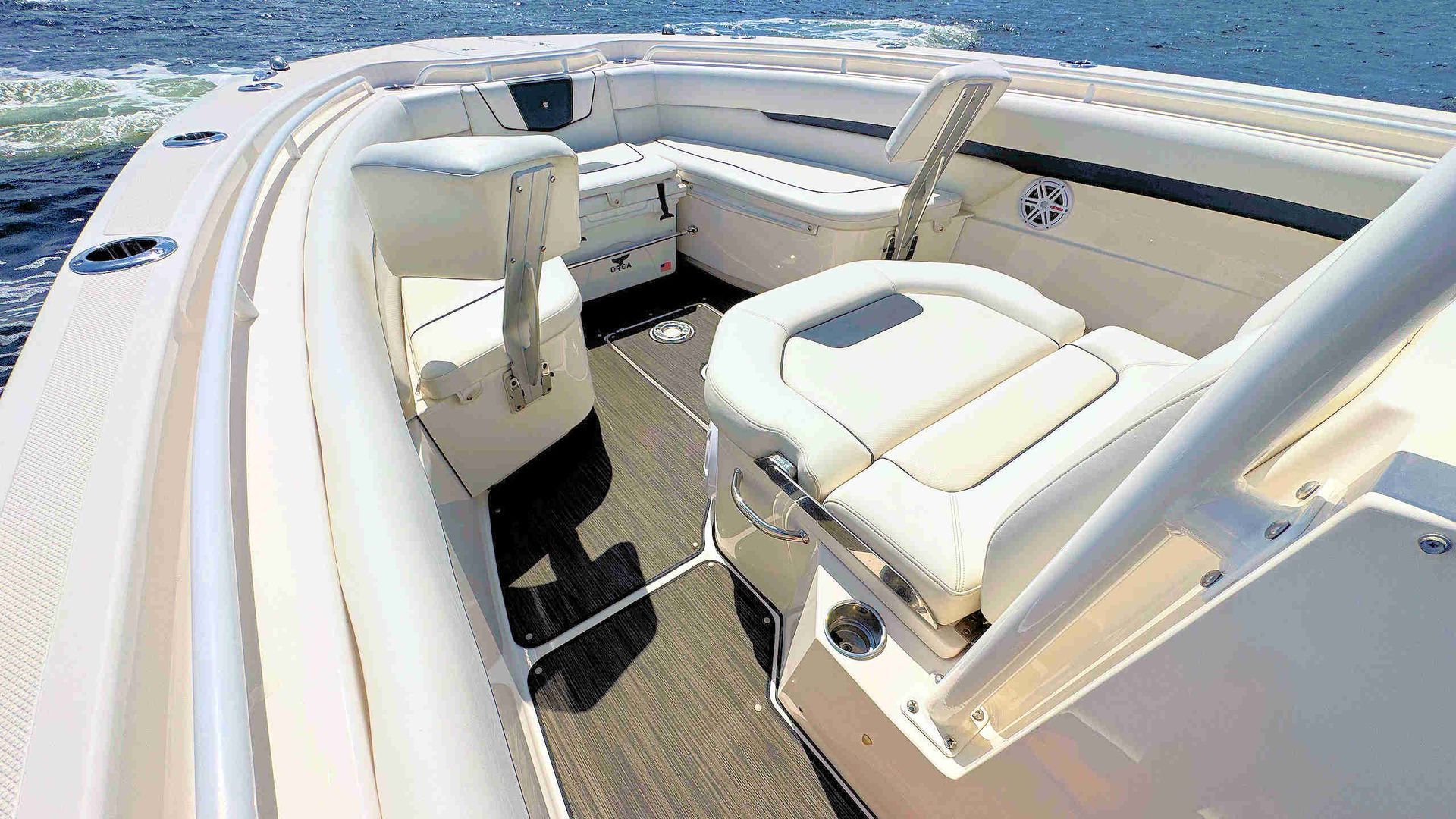 White cushioned seating in the boat bow with helm, under bright sunlight