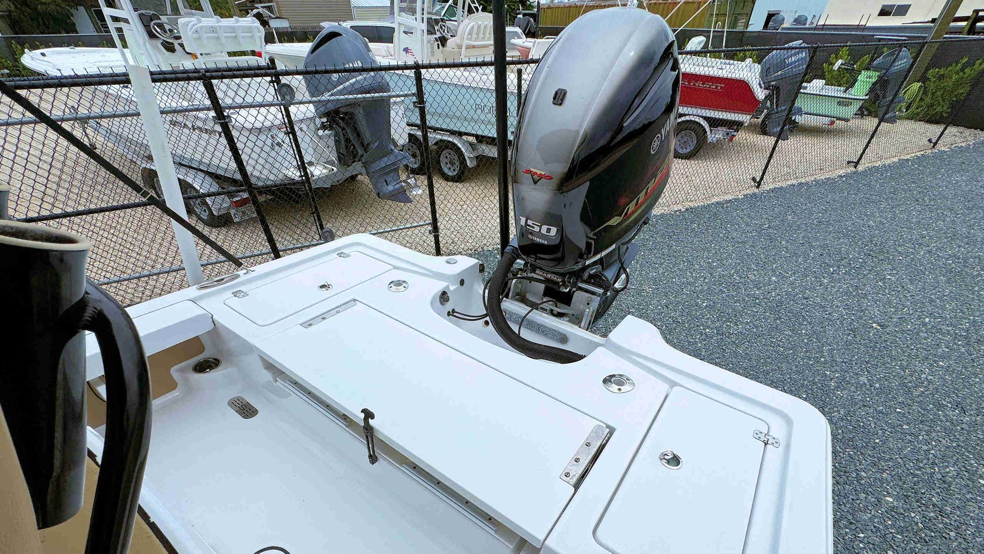 Boat cockpit with a gray outboard motor mounted at the stern, seen from the deck.