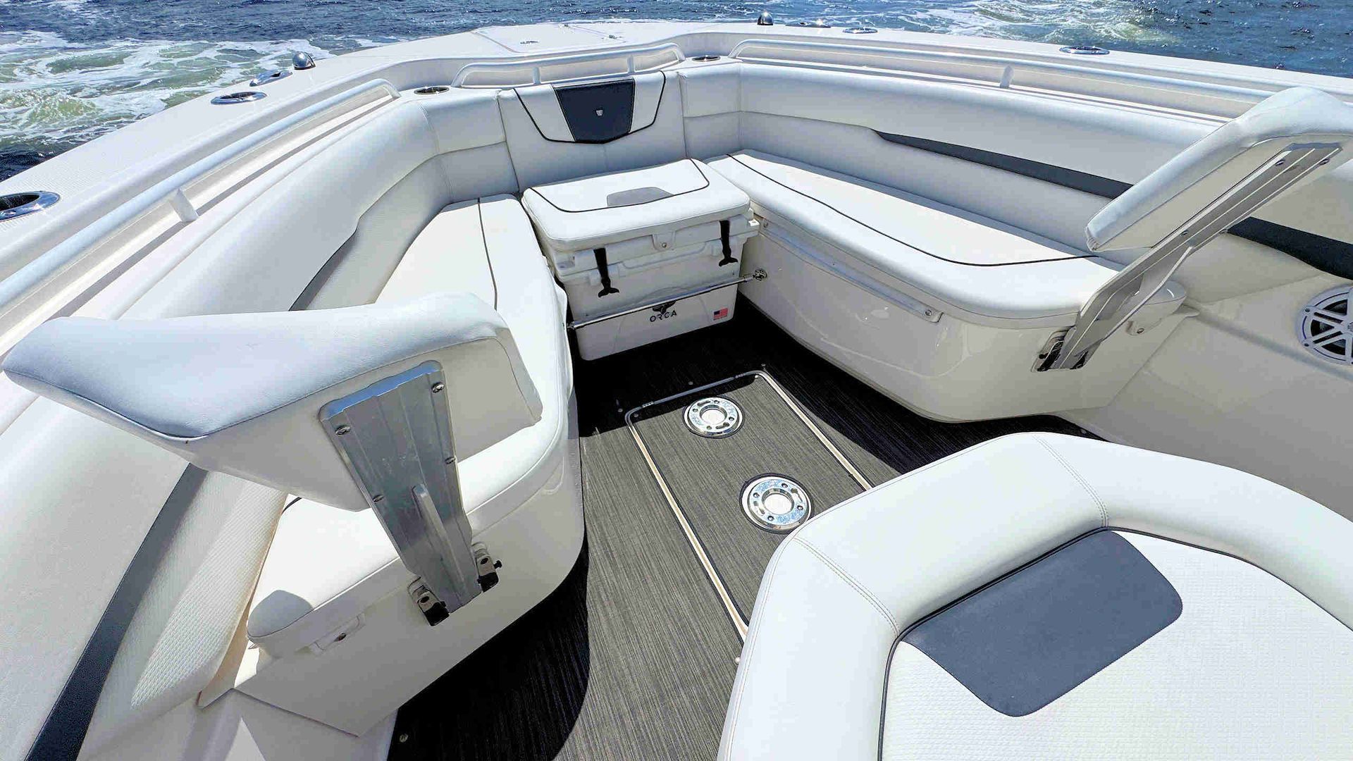 White boat bow with cushioned seating and a small table on a sunny day
