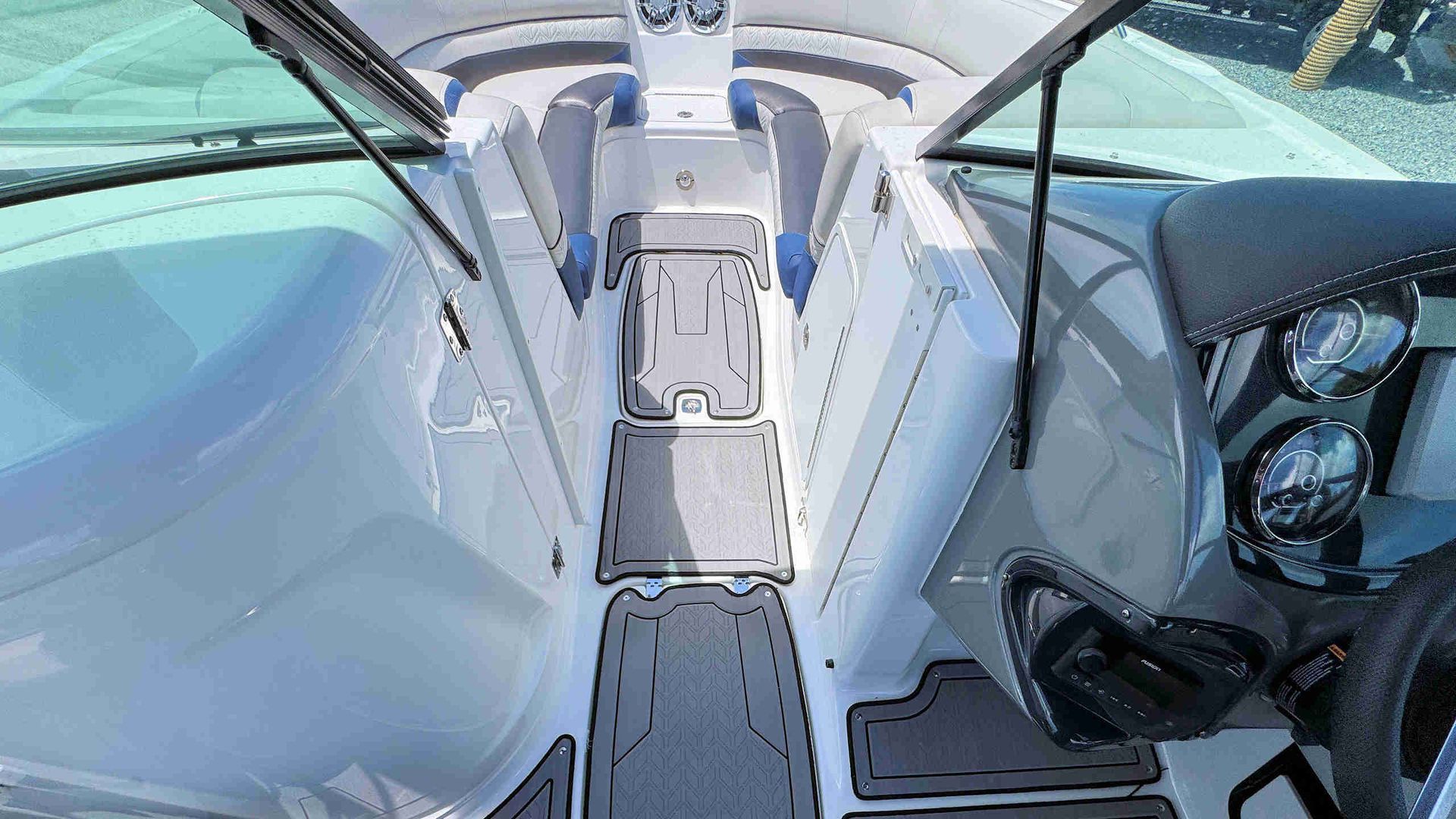 Boat cockpit with twin captain’s chairs and a narrow center walkway on a sunny day
