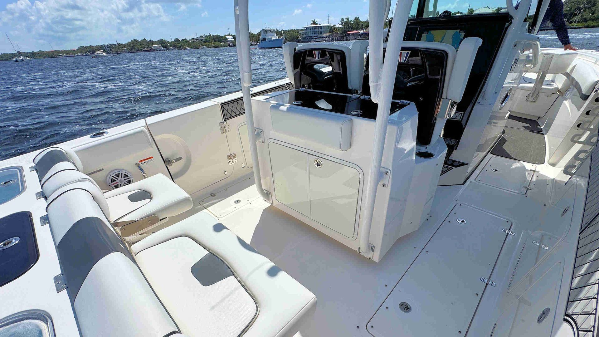White center-console boat cockpit with seating on calm water under a bright blue sky