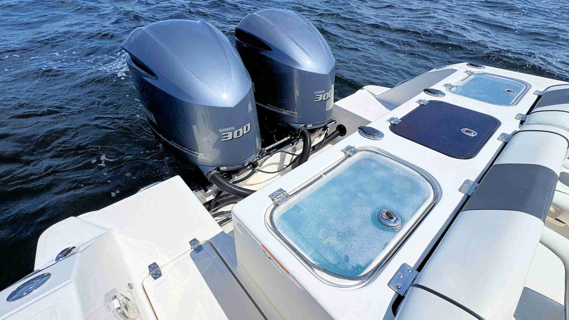 Boat stern with twin outboard motors and a small swim platform on open water