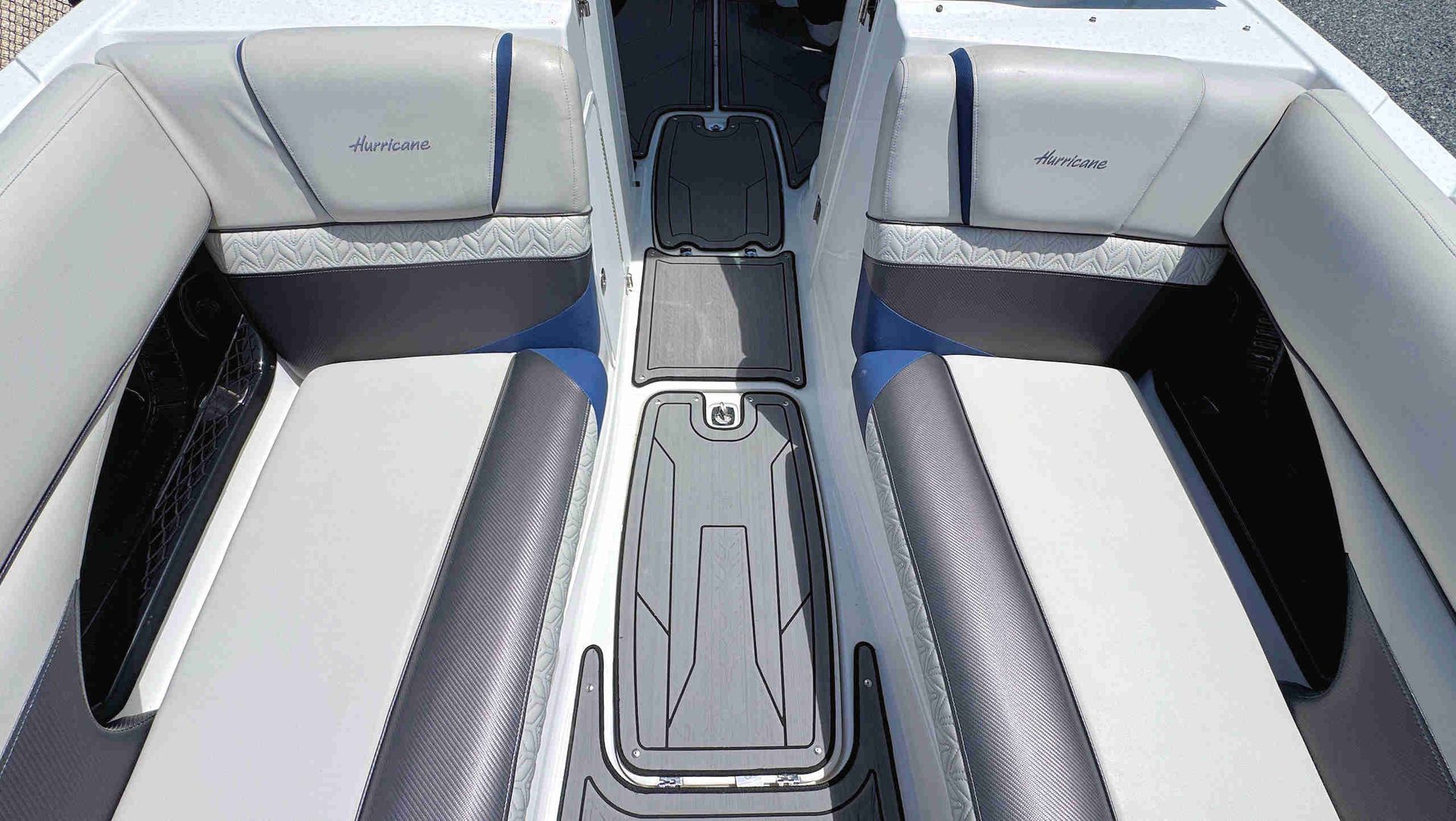 White and gray boat interior with cushioned bench seats and a central walkway