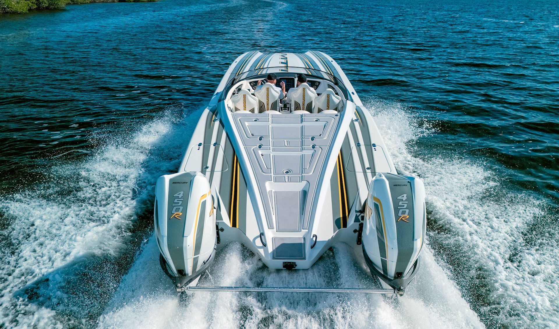 White powerboat speeding on blue water, creating wakes.