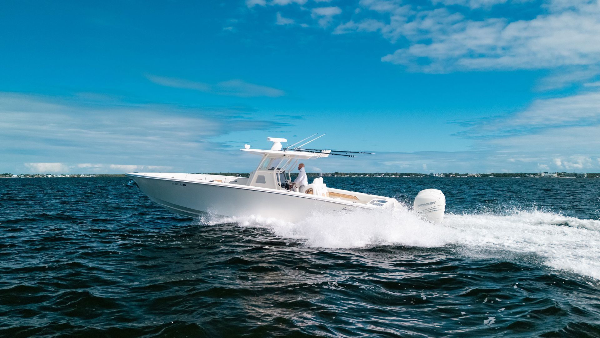 White center console boat speeding across choppy blue water under a bright sky