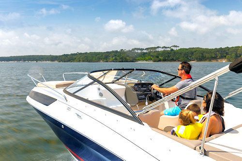 Family cruising the New York waterways in a blue and white motorboat.