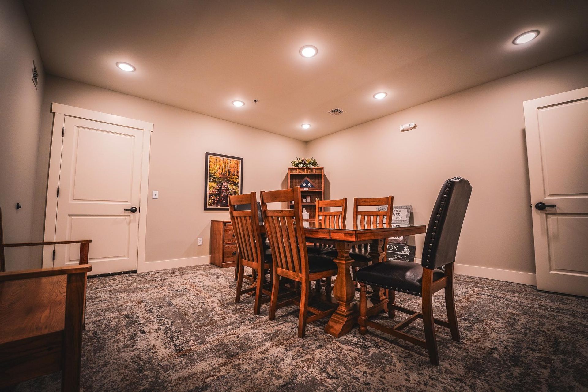 Dining room with wooden table and chairs, hardwood floor, and art.
