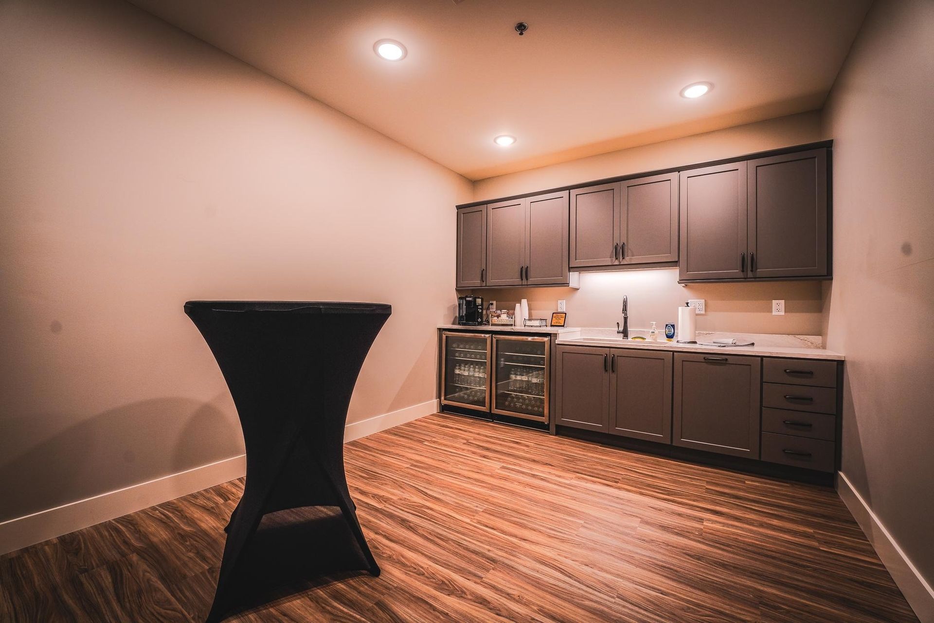 Empty room with kitchen cabinets, countertop, and a small table.