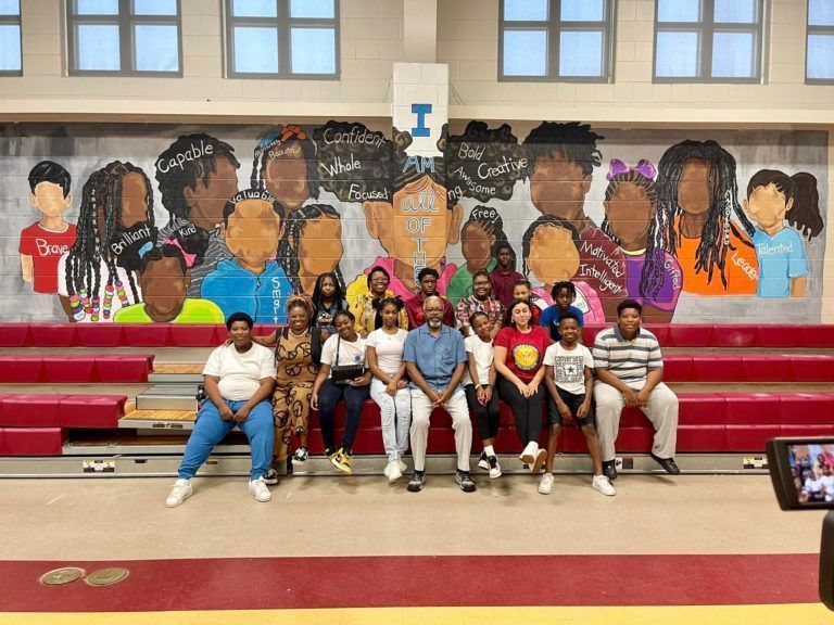 group in front of mural