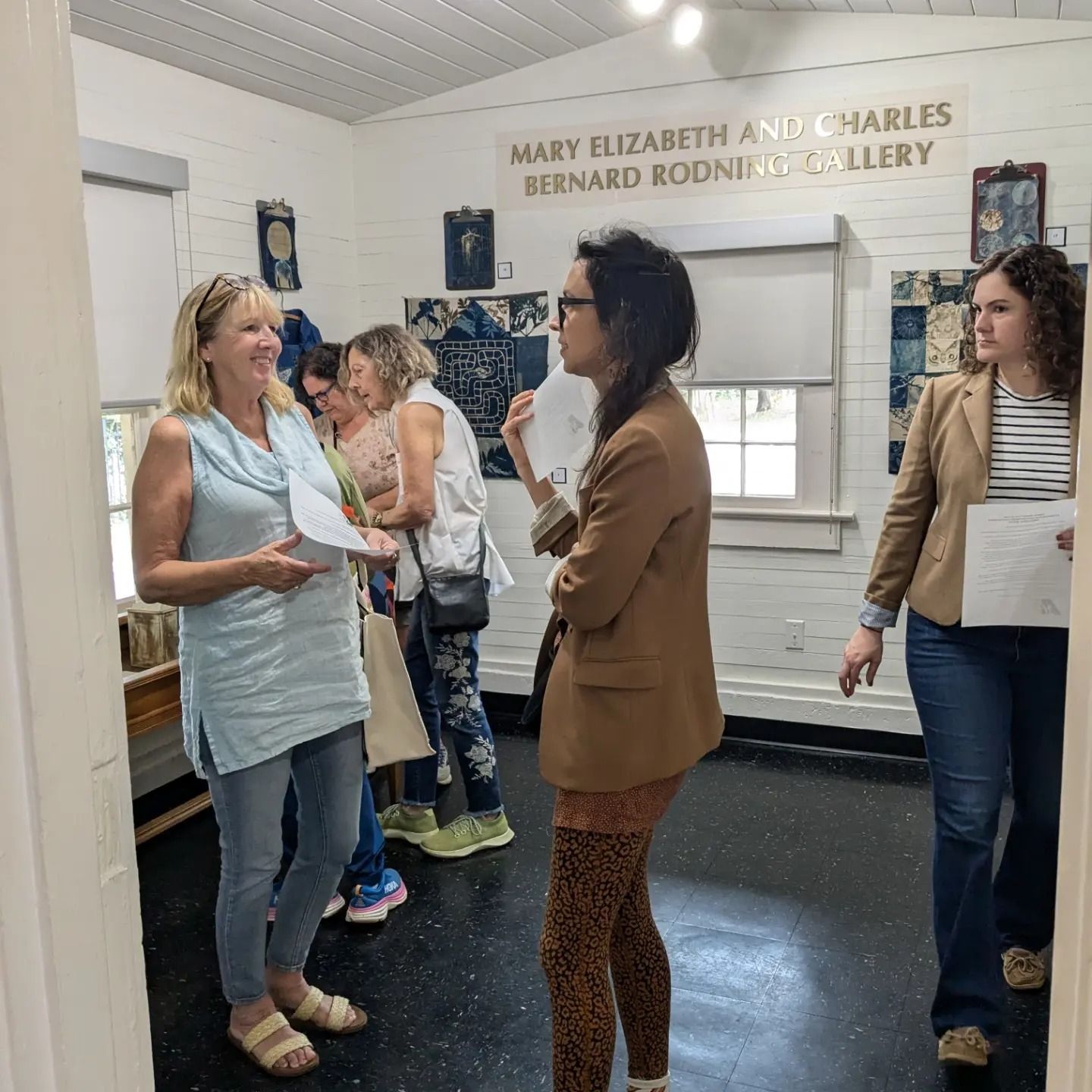Visitors in Mobile Medical Museum gallery observing exhibition by Douglas Baulos