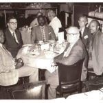 historic photo of men sitting around table