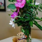 flower arrangement and stuffed animal on table