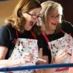 two women painting and smiling