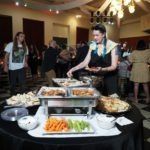 people mingling around table with food