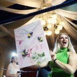 woman holding up painting