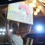 woman holding up painting