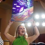 woman holding up painting