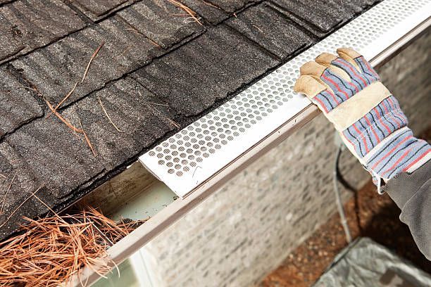 Installing a perforated metal gutter guard on a shingle roof