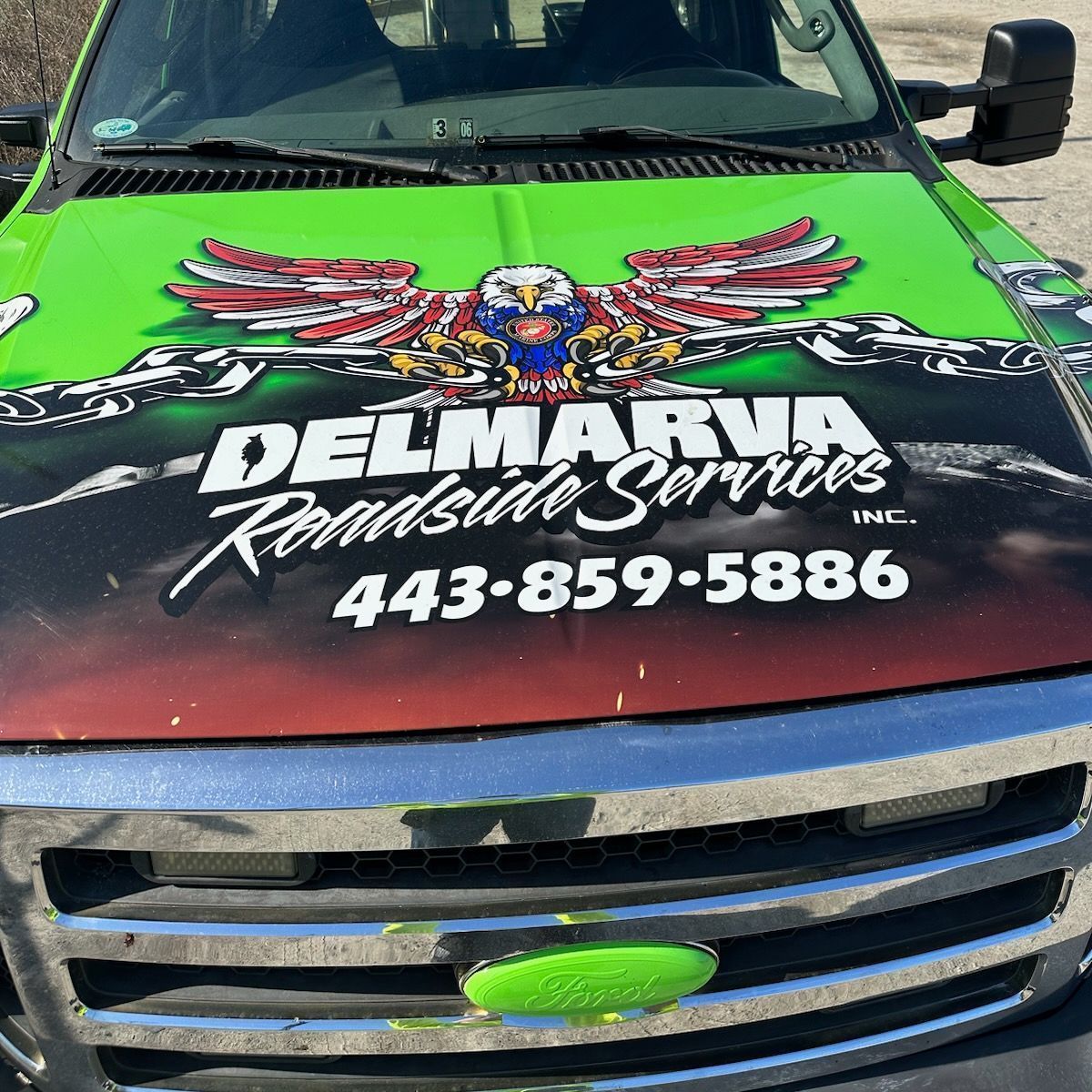 Bright green and black truck hood with Delmarr Reconditioning Services logo and phone number 443-859-5886