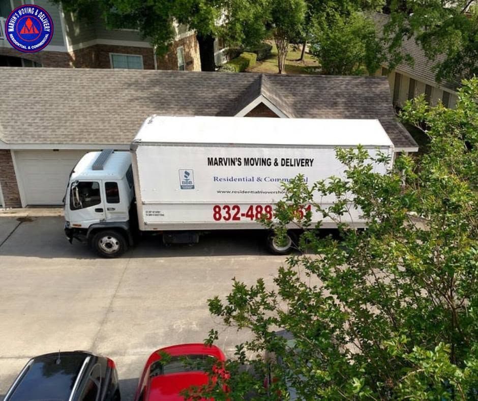 White moving truck parked by a house, labeled “Marlins Movers & Delivery,” with a phone number on the side.