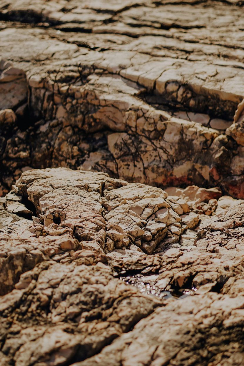 Close-up of cracked, dry rocky ground with layered tan and brown stone textures