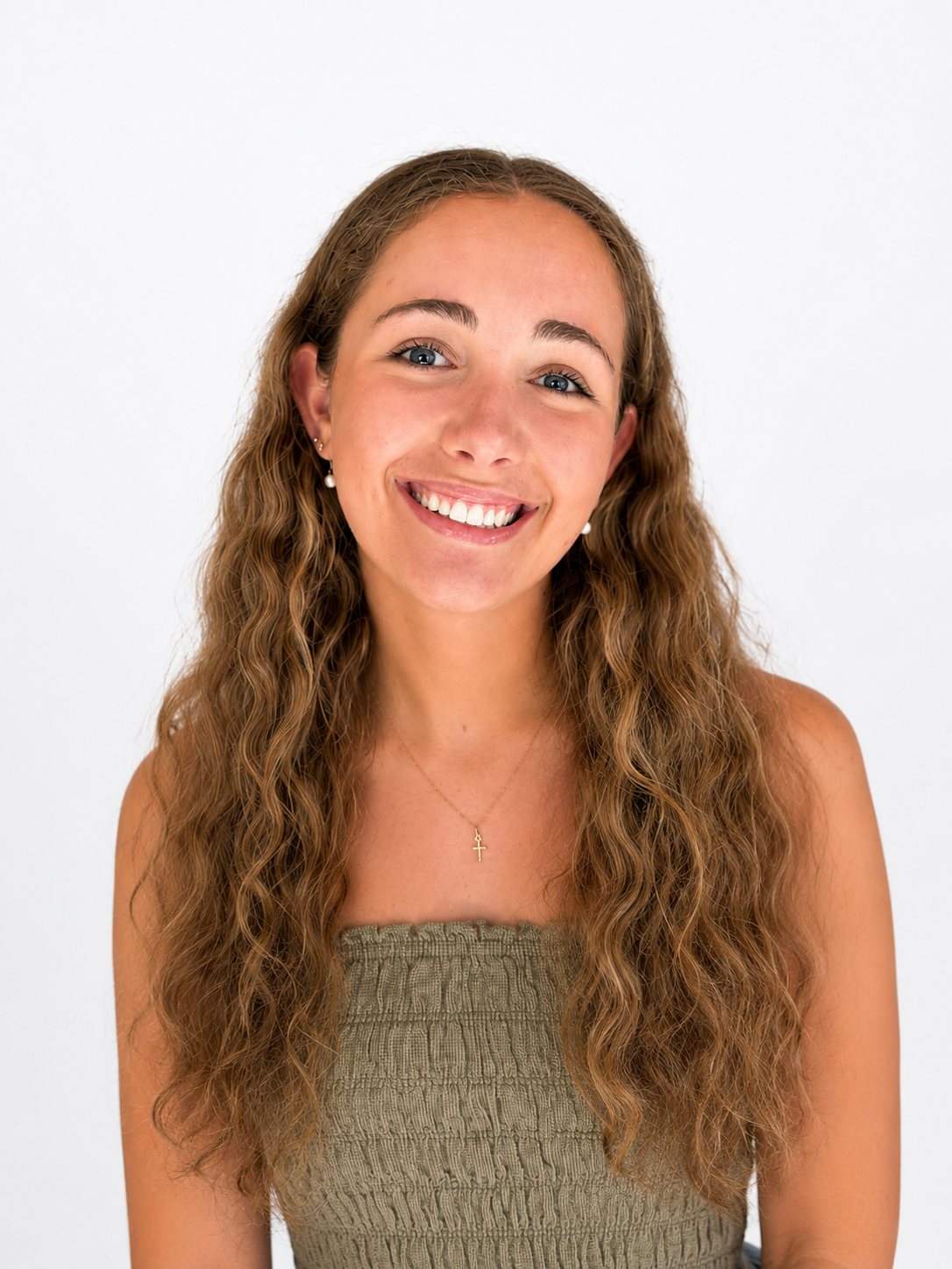 Smiling woman in a green strapless top against a white background