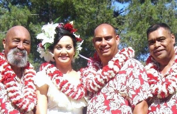 A bride and groom are posing for a picture with their wedding party