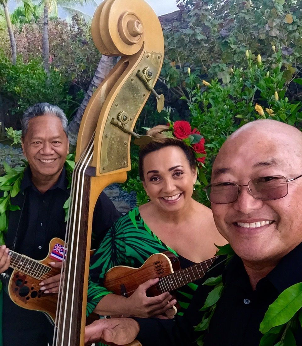 Two men and a woman holding ukuleles and a double bass