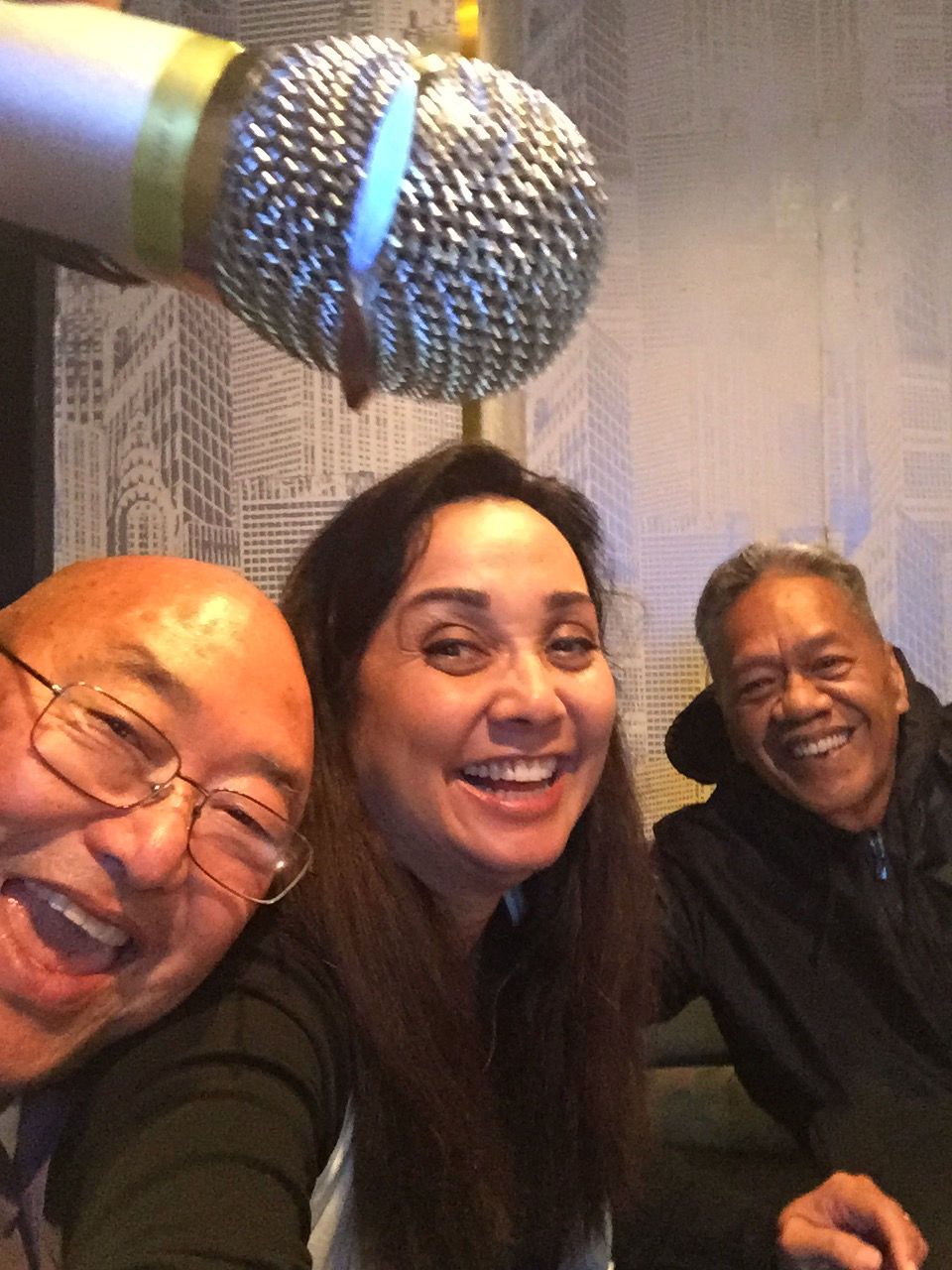 A group of people posing for a picture with a microphone in the background