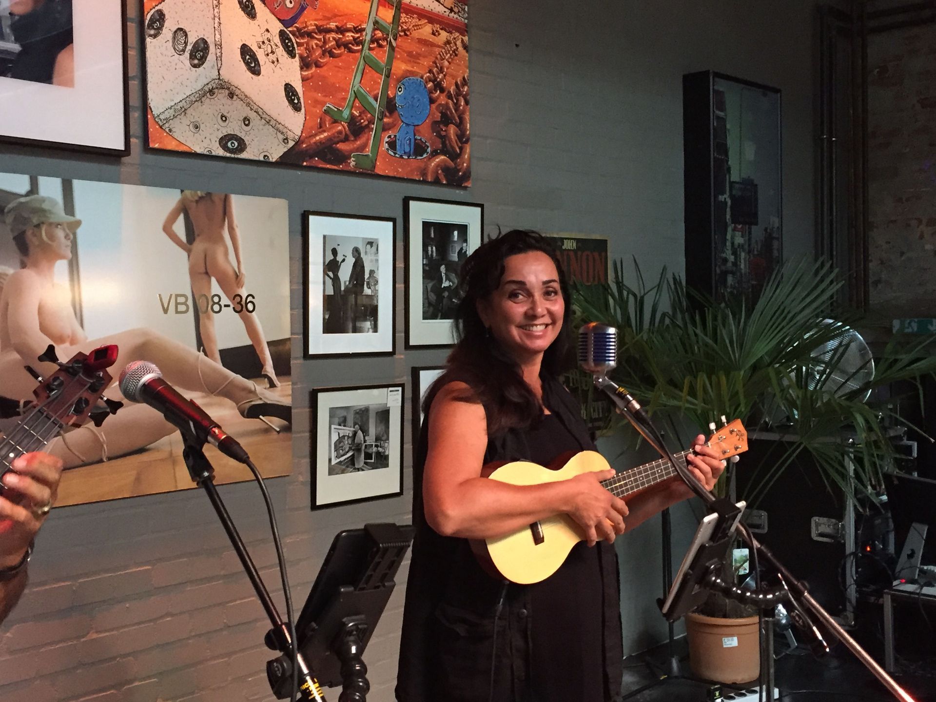 A woman is playing a guitar and singing into a microphone.