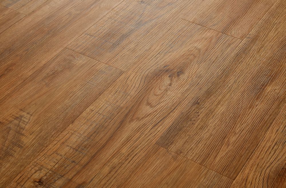 A close-up of brown wood-grain laminate flooring planks with visible textures and diagonal lines.