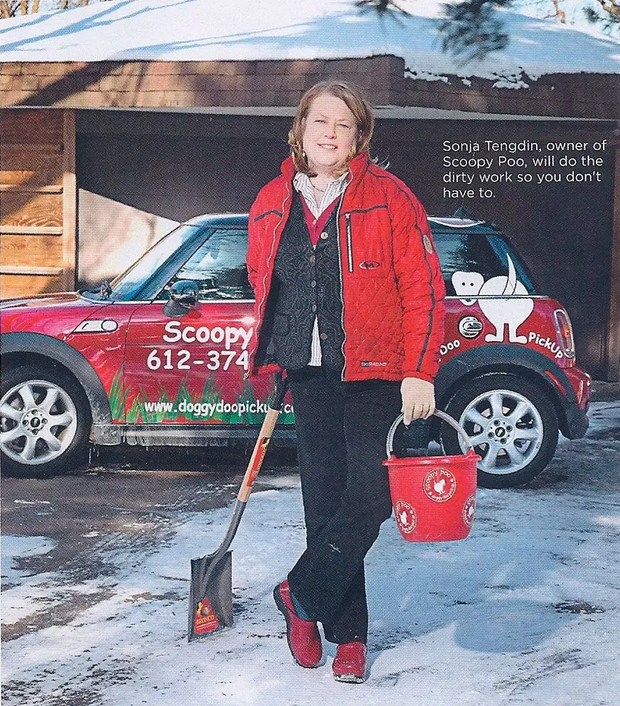 Woman in red jacket holds bucket and shovel, stands by red car with