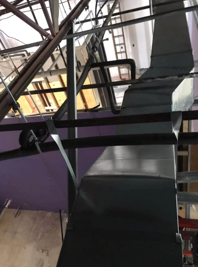 Black industrial staircase with metal railings in an indoor space