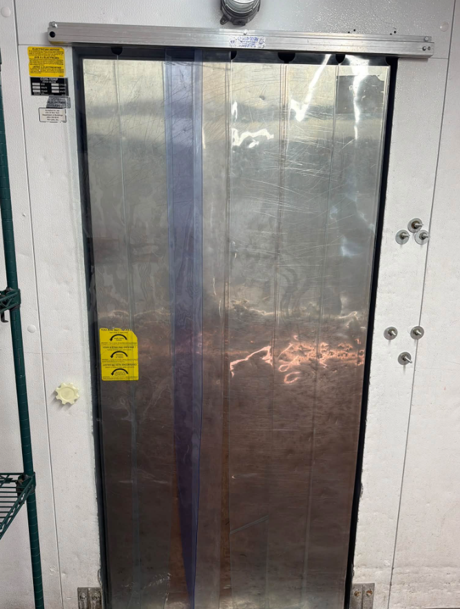 Open server cabinet with exposed wiring, circuit boards, and metal components outdoors.