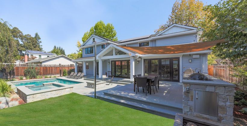 The backyard of a house with a swimming pool and a fireplace.