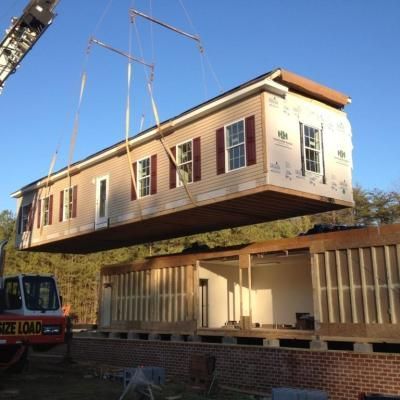 A large house is being lifted into place by a crane