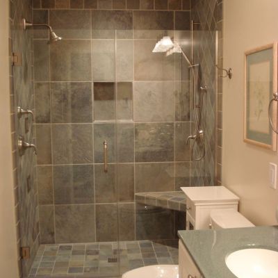 A bathroom with a toilet a sink and a walk in shower