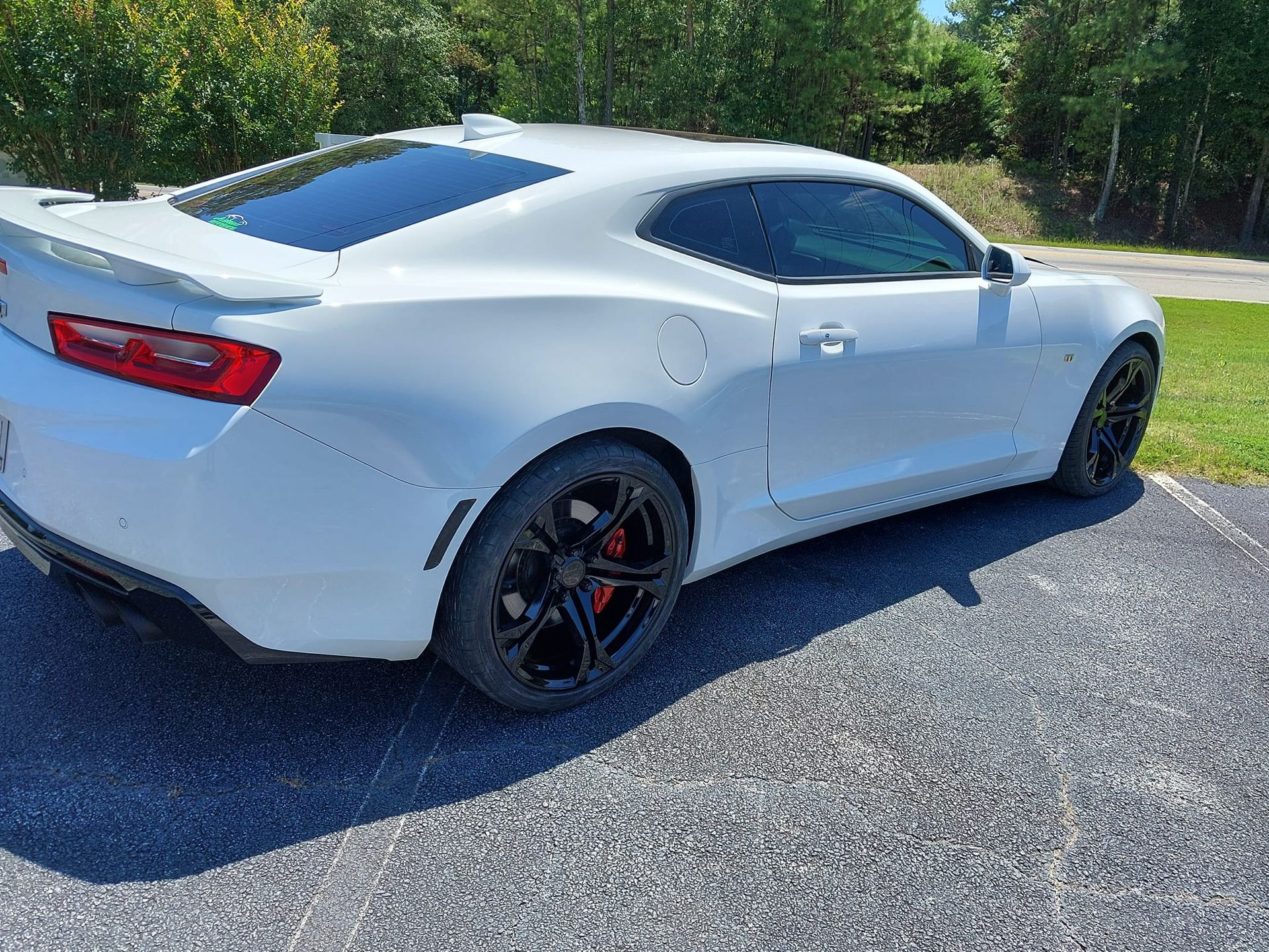 A white car is parked on the side of the road.