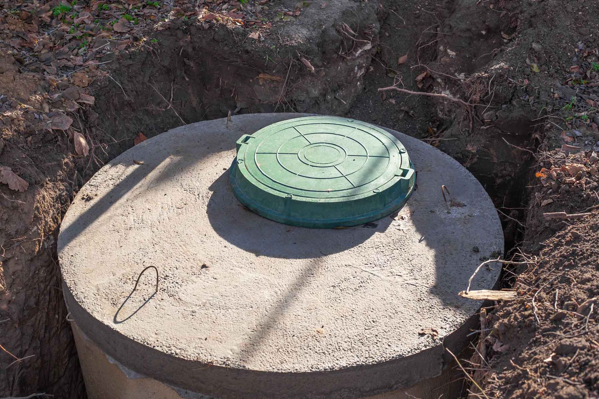Septic tank made of concrete rings with a hatch for a private country house.