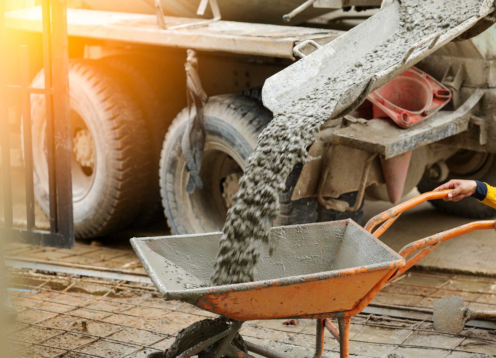 A truck is pouring ready-mixed concrete into a cart. A truck is pouring ready-mixed concrete into a cart.