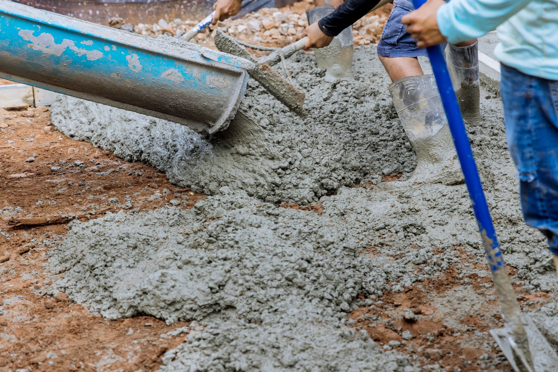 Construction workers pouring ready-mix concrete on-site for a durable building foundation. Construction workers pouring ready-mix concrete on-site for a durable building foundation.