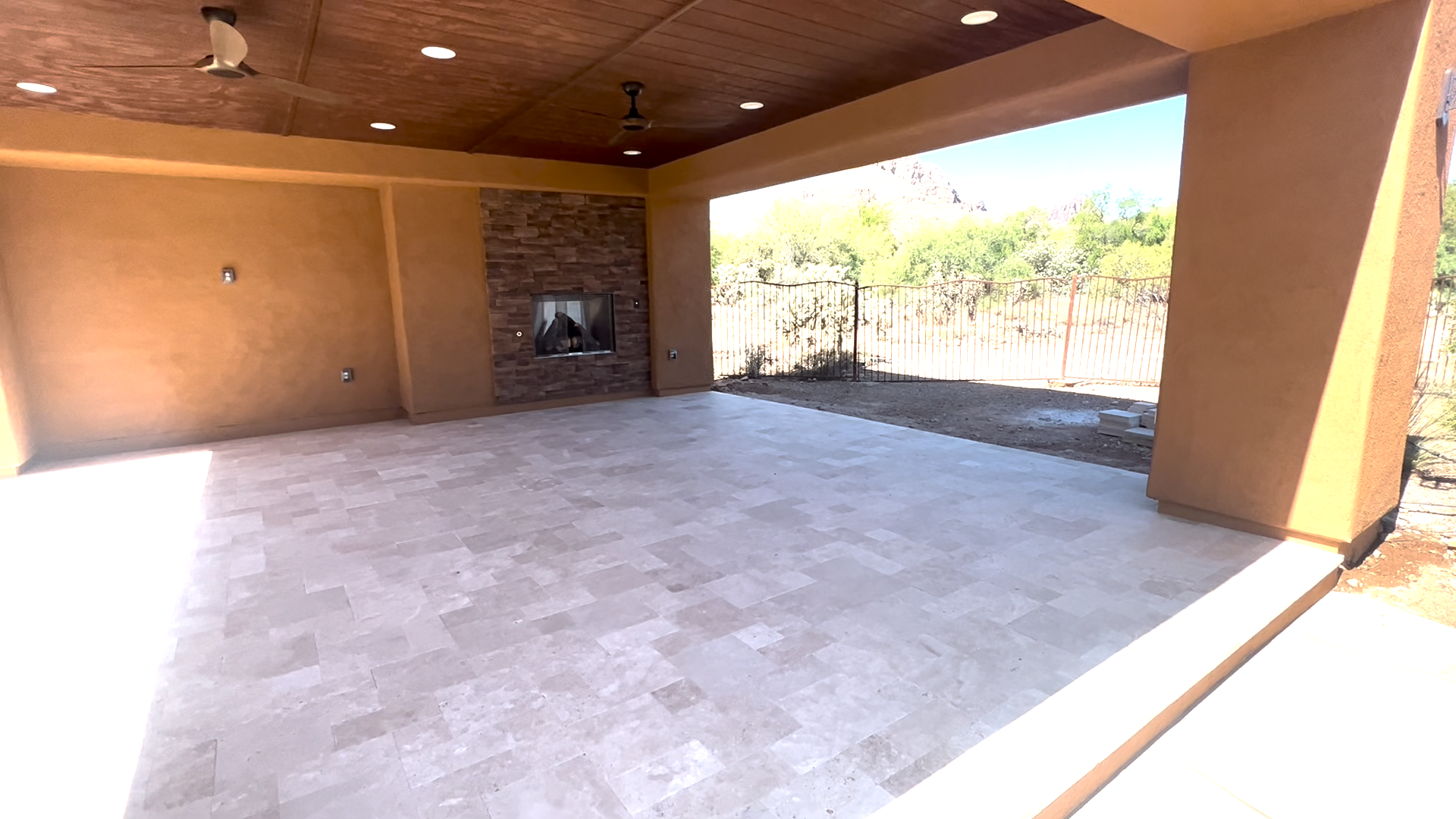 an outdoor living area  with tile floors and a fireplace