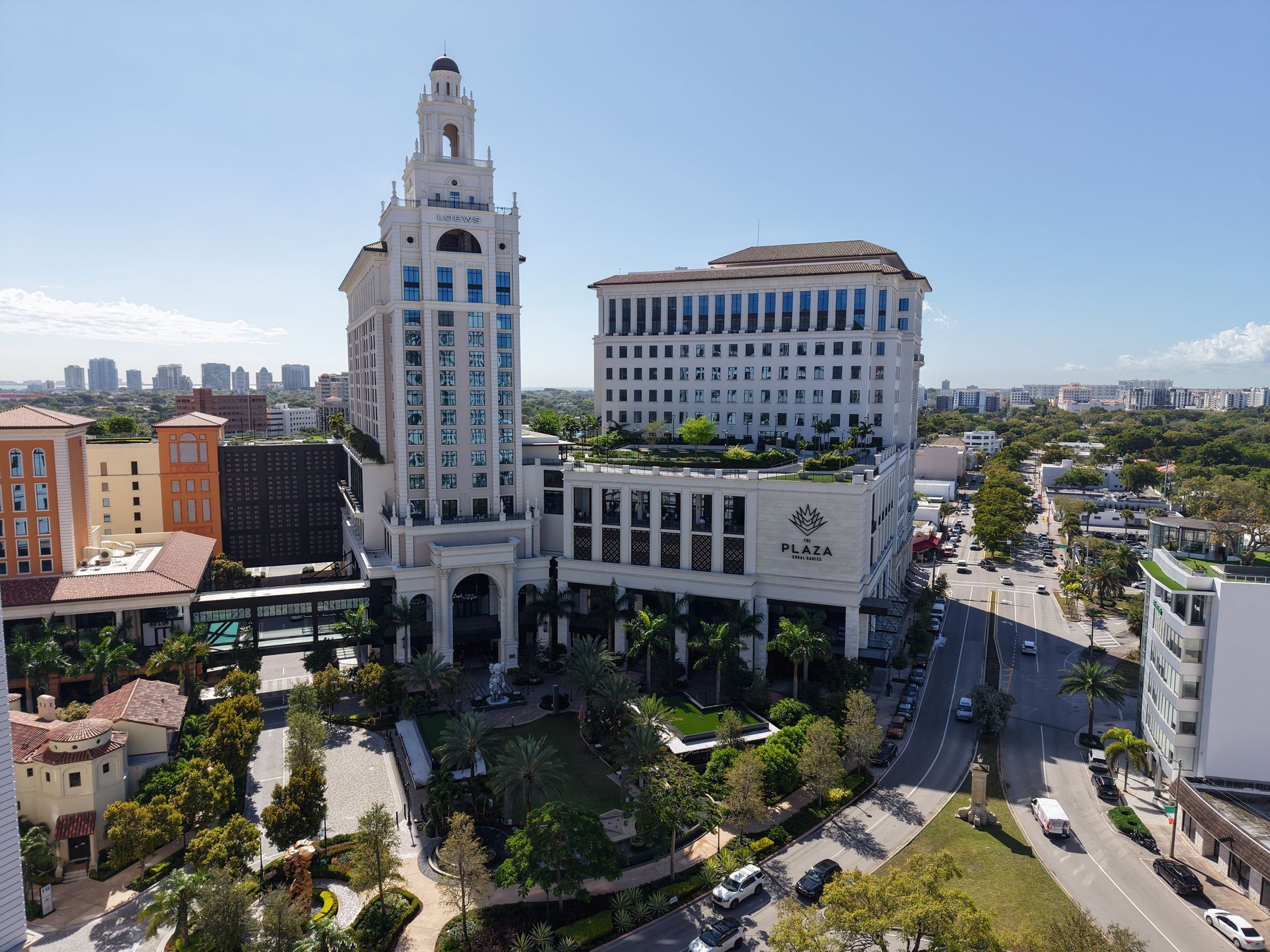 Aerial view of the white, neo-classical Altea hotel building in Coral Gables with a clock tower and courtyard.