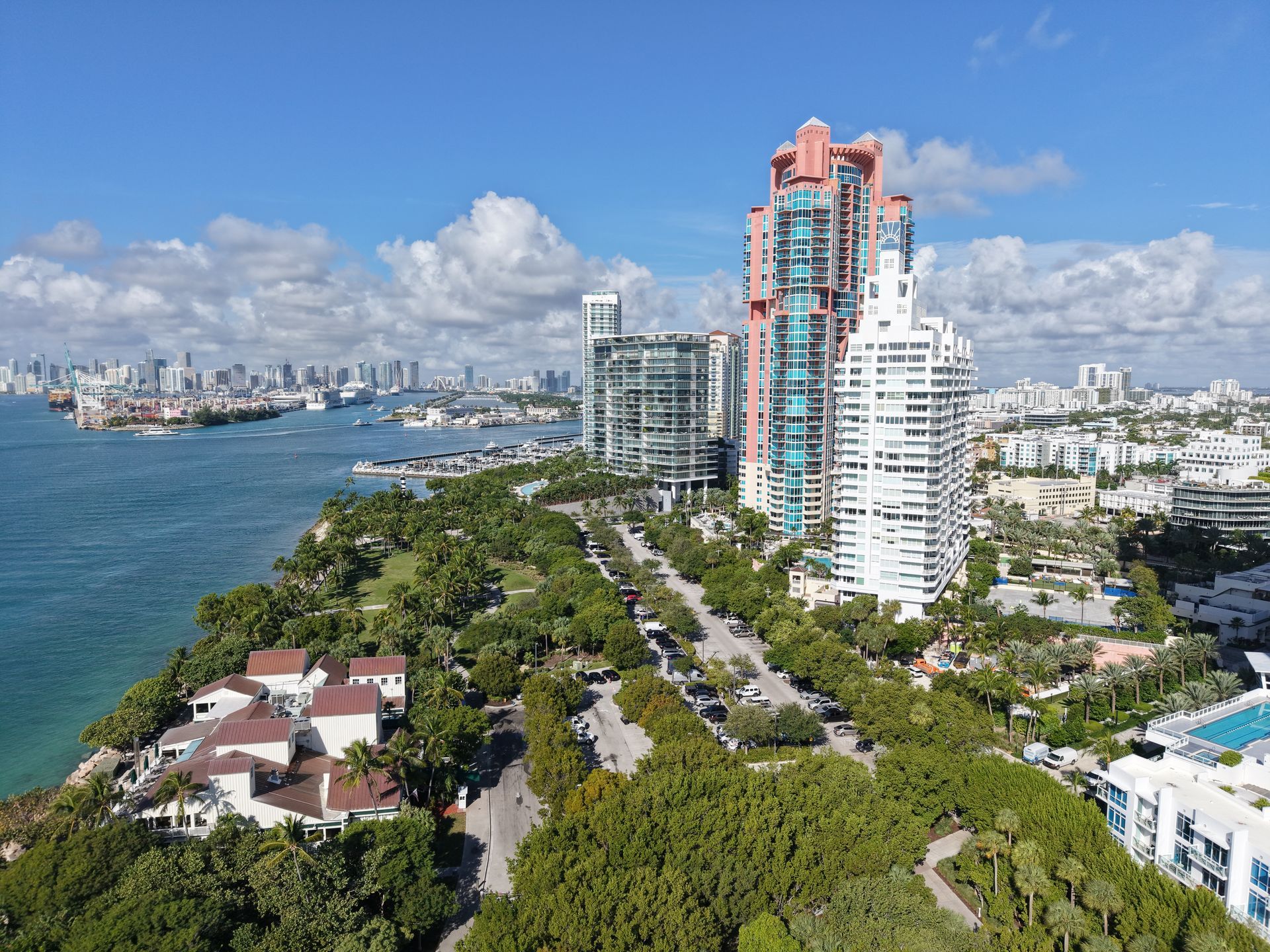 Aerial view of South Pointe Park in Miami Beach with tall residential towers, lush trees, and the Atlantic Ocean.