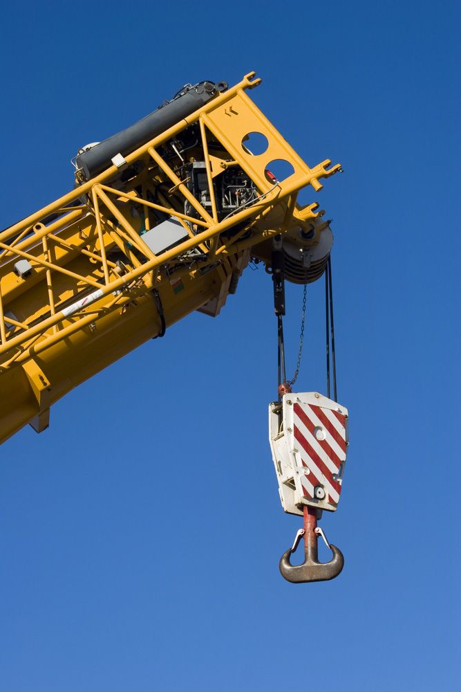 A Yellow Crane With A Hook Attached To It Against A Blue Sky — Gympie Crane Hire In Glanmire, QLD