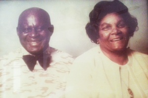 Two smiling people posed side by side against a plain light background.
