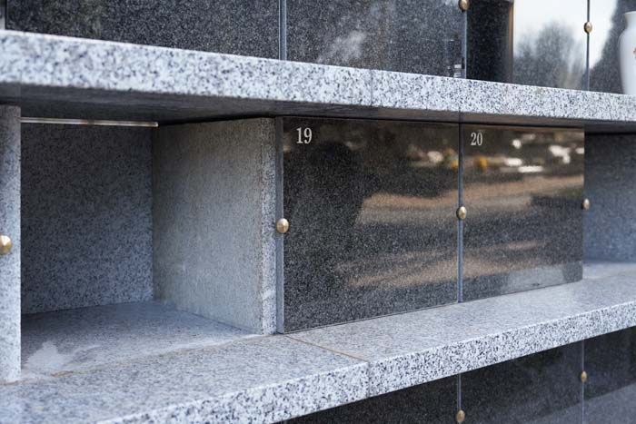 Columbarium niches with granite fronts and numbered doors in a mausoleum wall