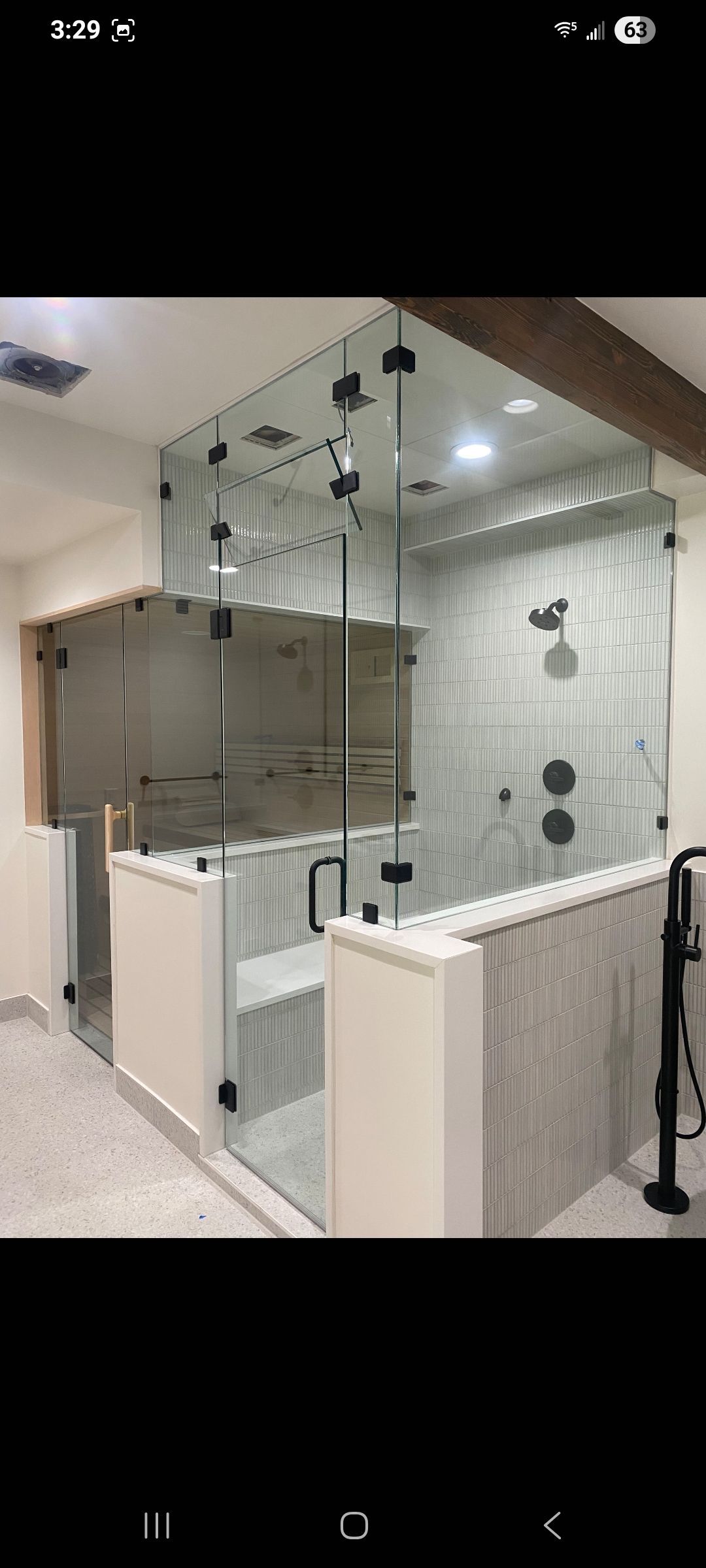 Modern bathroom with glass shower enclosure, white vanity, and ceiling lights